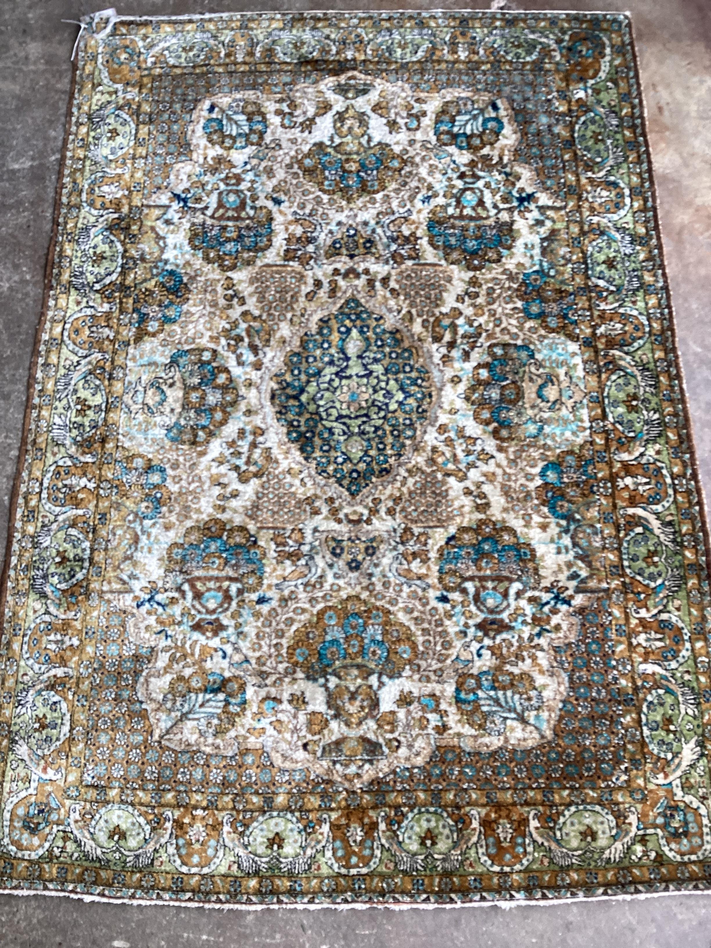 A Tabriz silk rug, woven with floral bouquets about a central medallion, 154 x 111cms
